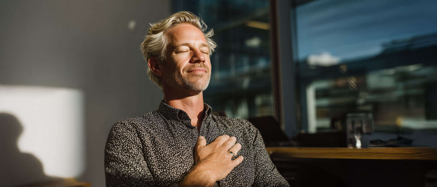 Bild av man som medvetet andas och reflekterar i ett kontorslandskap.