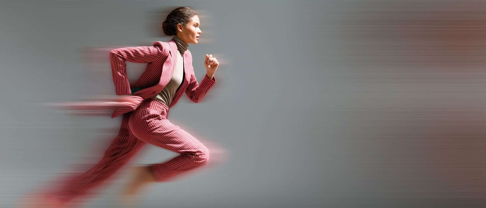 Kvinna i professionell kostym löper framåt, symboliserar snabbhet och effektivitet inom rekrytering.